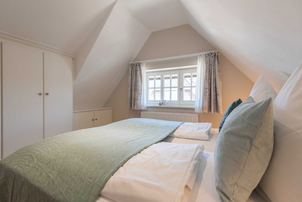 im zweiten Schlafzimmer im App. 12 im Haus Carmen gibt es ein Doppelbett, Fenster und Einbauschränke