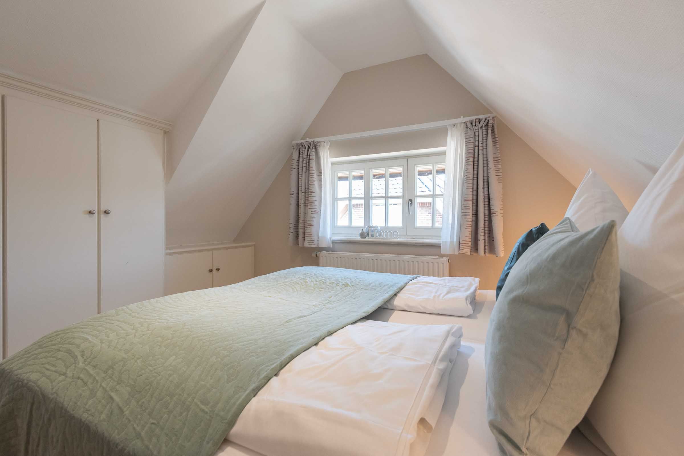 im zweiten Schlafzimmer im App. 12 im Haus Carmen gibt es ein Doppelbett, Fenster und Einbauschränke