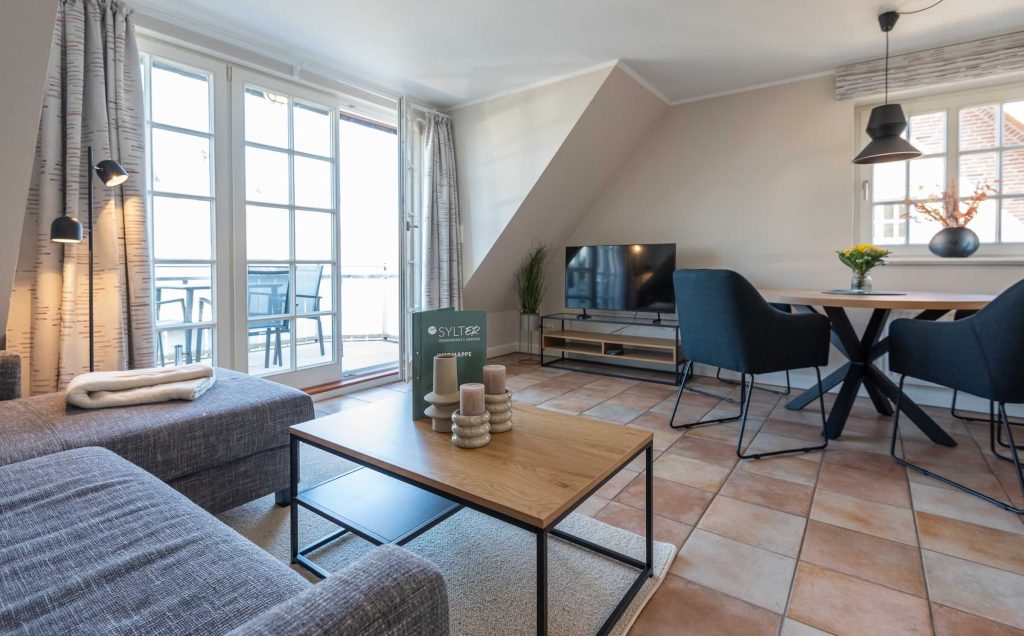 im Wohnzimmer der Ferienwohnung Carmen App. 12 steht ein Sofa mit TV