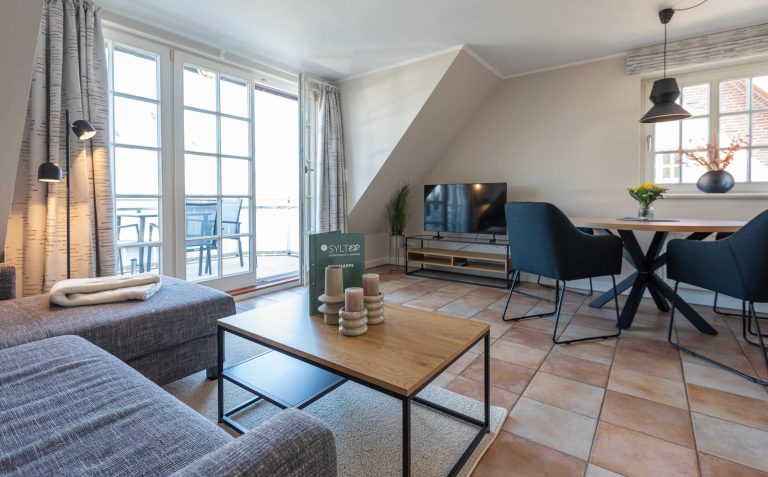 im Wohnzimmer der Ferienwohnung Carmen App. 12 steht ein Sofa mit TV