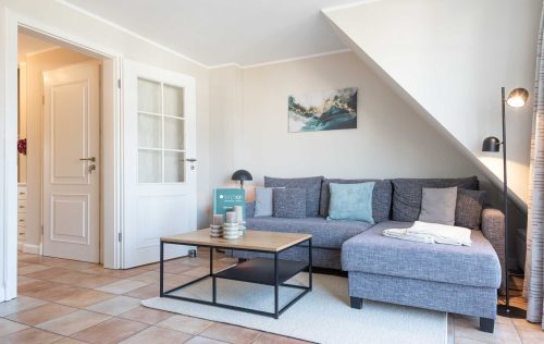 auf dem Sofa in der Ferienwohnung Carmen App. 12 liegen Kissen und eine Leselampe steht daneben